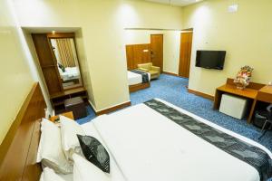 a hotel room with a large bed and a television at Richmond Hotel & Suites in Dhaka