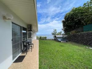 a patio with a view of the ocean from a house at REA Lodge in Punaauia