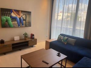 a living room with a blue couch and a table at Cosy appartement à Ain Diab beach in Casablanca