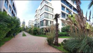 a brick sidewalk in front of a tall building at Cosy appartement à Ain Diab beach in Casablanca