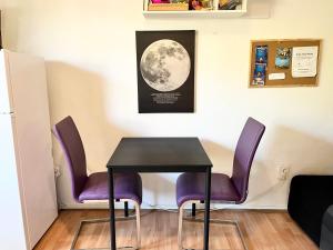 tavolo e sedie in una stanza con la luna sul muro di Veronika's House a Pola (Pula)