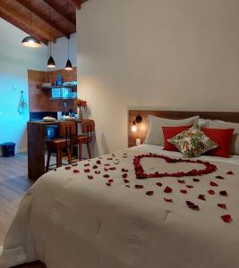 聖特雷莎的住宿－Villaggio di Itália Chalés，一间卧室,床上有红色玫瑰