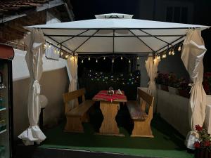 um gazebo com uma mesa e cadeiras por baixo em Къща за гости “Краси” em Yagodina