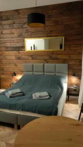 sypialnia z łóżkiem z drewnianą ścianą w obiekcie Studio Dąbrowa Żeromskiego w mieście Dąbrowa Górnicza