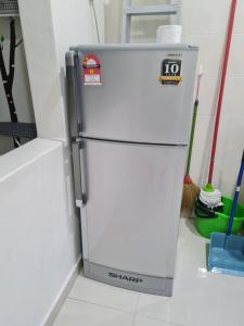 un frigorifero bianco seduto in una cucina accanto a un muro di Air-home No135 Kampung Boyan, 3BR, 6pax Netflix a Taiping