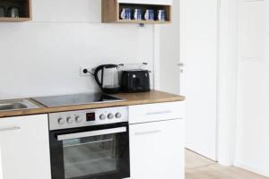 een keuken met witte kasten en een fornuis met oven bij Beautiful apartment in Bad Soden in Bad Soden am Taunus