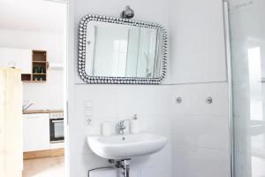 een witte badkamer met een wastafel en een spiegel bij Beautiful apartment in Bad Soden in Bad Soden am Taunus