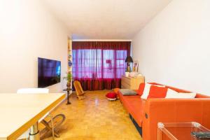 ein Wohnzimmer mit einem Sofa und einem roten Vorhang in der Unterkunft A 3 km du centre ville in Brüssel