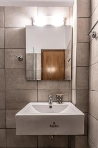 a bathroom with a white sink and a mirror at Mike's Apartments in Nei Poroi