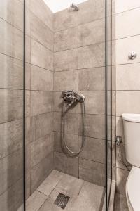 a shower with a glass door in a bathroom at Mike's Apartments in Nei Poroi