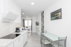 a white kitchen with a table and a microwave at Lightbooking 7 Palmas in Las Palmas de Gran Canaria