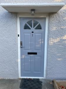 uma porta azul em um edifício branco com aphalt em London Studio em Chingford