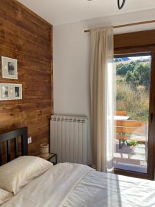 a bedroom with a bed and a sliding glass door at Apartmani 1490 in Žabljak