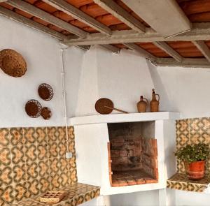 a living room with a fireplace with wooden ceilings at Nina's Stay Hostel in Charneca