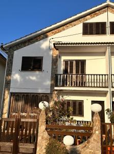 une maison avec une clôture en bois devant elle dans l'établissement Nina's Stay Hostel, à Charneca