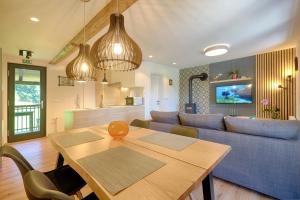ein Wohnzimmer mit einem Tisch und einem blauen Sofa in der Unterkunft Apartments Pri Fencu in Jesenice