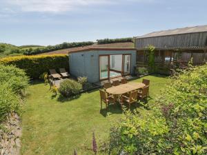 a garden with a table and chairs and a shed at Owls Roost in Saint Goran