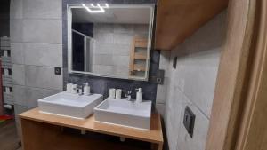 uma casa de banho com 2 lavatórios brancos e um espelho em Apartmán Pavel em Tux