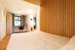 a bedroom with a large bed with a wooden wall at Apartments Pri Fencu in Jesenice