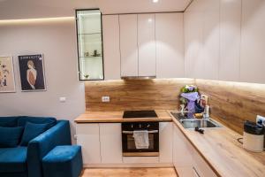 a small kitchen with a sink and a blue couch at 2BR at Café Flora - Skanderbeg Square Area in Tirana