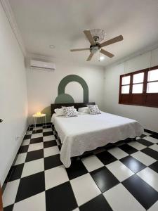 1 dormitorio con 1 cama y suelo blanco y negro a cuadros en Casa Diana Culzat, en Ciénaga