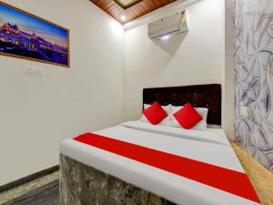 1 dormitorio con 1 cama grande con almohadas rojas en Super OYO Flagship Hotel R.m Havel en Kota