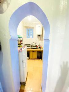 un arco in una cucina con frigorifero bianco di Casa Marisco a Chefchaouen