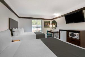 a hotel room with two beds and a flat screen tv at Stoke Hotel SureStay Collection by Best Western in Revelstoke +25 photos