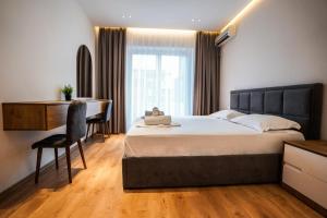 a bedroom with a bed and a desk and a chair at 2BR at Café Flora - Skanderbeg Square Area in Tirana