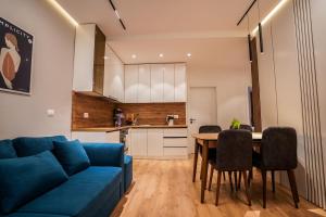 a living room with a blue couch and a table at 2BR at Café Flora - Skanderbeg Square Area in Tirana
