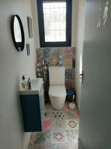 a bathroom with a toilet and a sink and a window at Villa-piscine privative en Haute Provence in Oraison