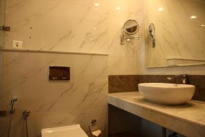 a bathroom with a sink and a mirror and a toilet at The Place Gurugram, a member of Radisson Individuals in Gurgaon