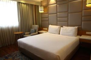 a hotel room with a large bed and a chair at The Place Gurugram, a member of Radisson Individuals in Gurgaon