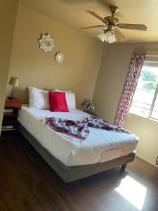 a bedroom with a bed with red pillows and a ceiling fan at All season vacation home! in Cottonwood
