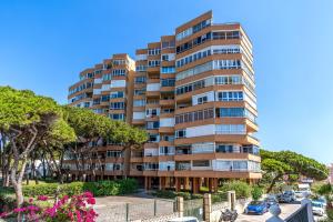 a tall apartment building with a parking lot at Modern studio apartment with sea views 5 min from the beach in Sitio de Calahonda
