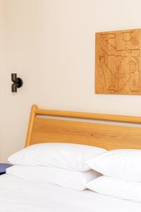 a bed with a wooden headboard and white pillows at YOWIE Hotel in Philadelphia