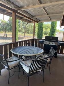 einen Tisch und Stühle auf einer Veranda mit Grill in der Unterkunft All season vacation home! in Cottonwood