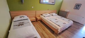 two beds in a room with green walls at Apartments Villa Bella Vista Hvar in Hvar