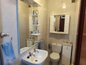 a bathroom with a sink and a toilet and a mirror at Amplio Apartamento con terraza a 150 m playa in Porto do Son +23 photos