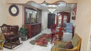 een woonkamer met een tafel en stoelen en een klok bij العشرين فيصل الجيزة in Caïro