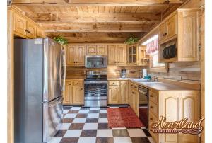a kitchen with wooden cabinets and stainless steel refrigerator at Halfway To Heaven in Sevierville