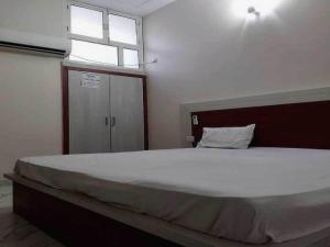 ein Schlafzimmer mit einem großen Bett mit Fenster in der Unterkunft Hotel O G Hotel Happy Home in Aligarh