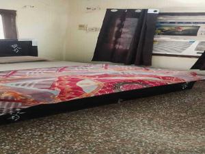 Bett mit einer roten Bettdecke in einem Zimmer in der Unterkunft Hotel O G Hotel Happy Home in Aligarh + 43 Fotos