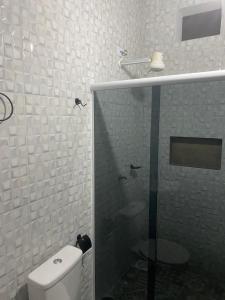 uma casa de banho com uma cabina de duche em vidro e um WC. em Pousada Camping e Pesca Bom Abrigo em Cananéia