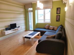 a living room with a couch and a tv at Apartment Lora in Burgas