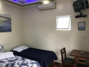 sypialnia z łóżkiem, stołem i oknem w obiekcie Pousada Camping e Pesca Bom Abrigo w mieście Cananéia