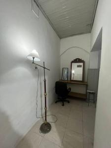 Mono ambiente céntrico Formosa في فورموزا: غرفة بها مصباح ومكتب وكرسي