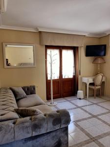 ein Wohnzimmer mit einem Sofa und einem Tisch in der Unterkunft Casa de Huéspedes Vecinodecerbantes in Alcalá de Henares