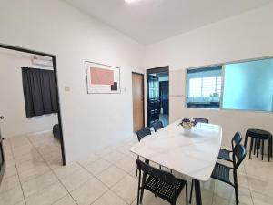 a dining room with a white table and chairs at Air-home M1 Simpang near Aulong Econsave, 4BR, 10pax, Netflix in Simpang