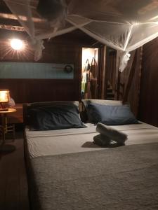 a bedroom with two beds and a canopy at Casa tartaruga in Castelhanos